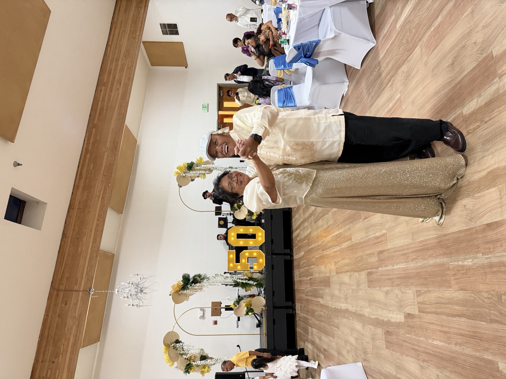 Butch and Inday dancing beneath the 50 marquee at their golden anniversary